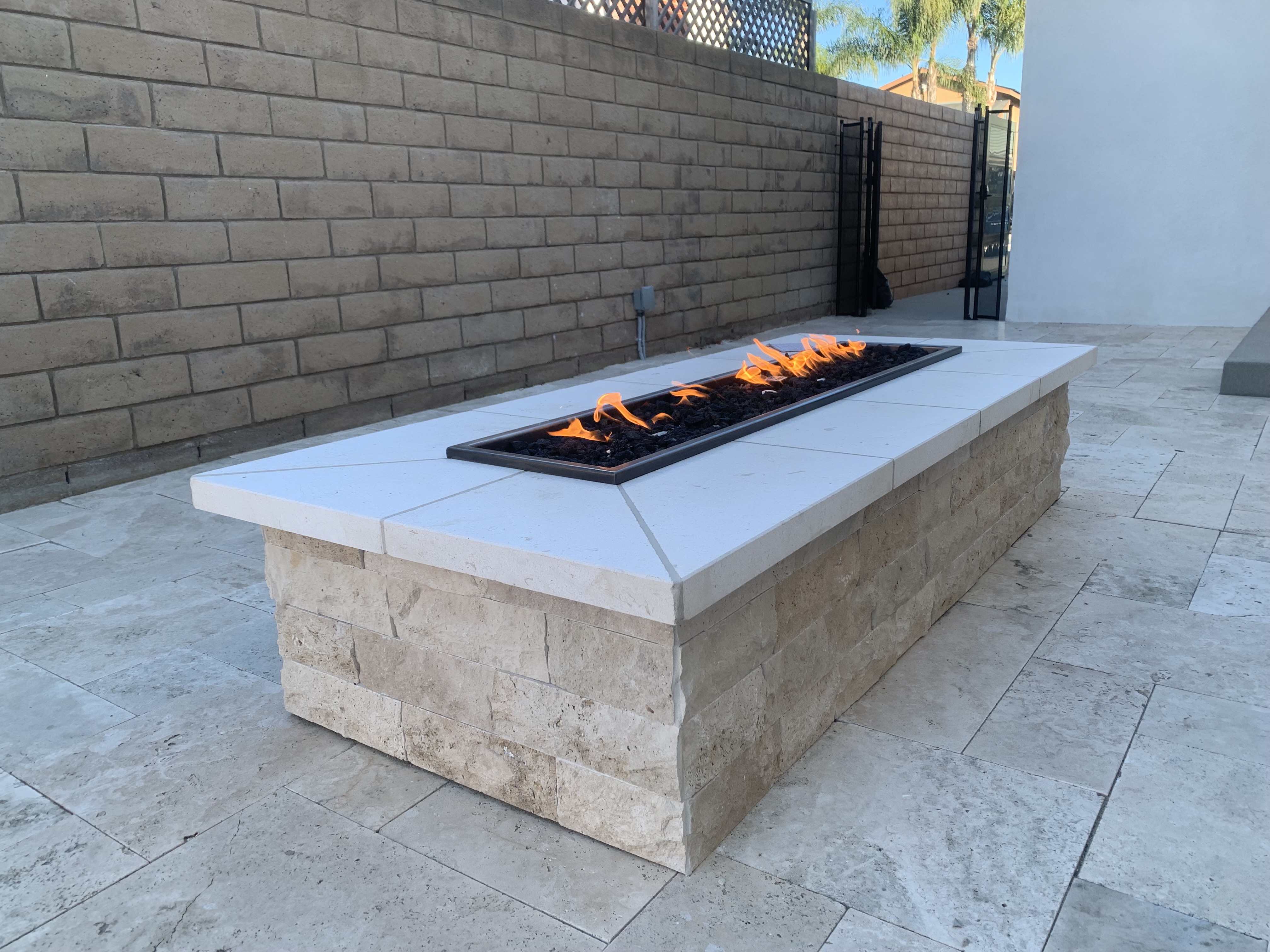 Custom travertine fire pit with limestone cap