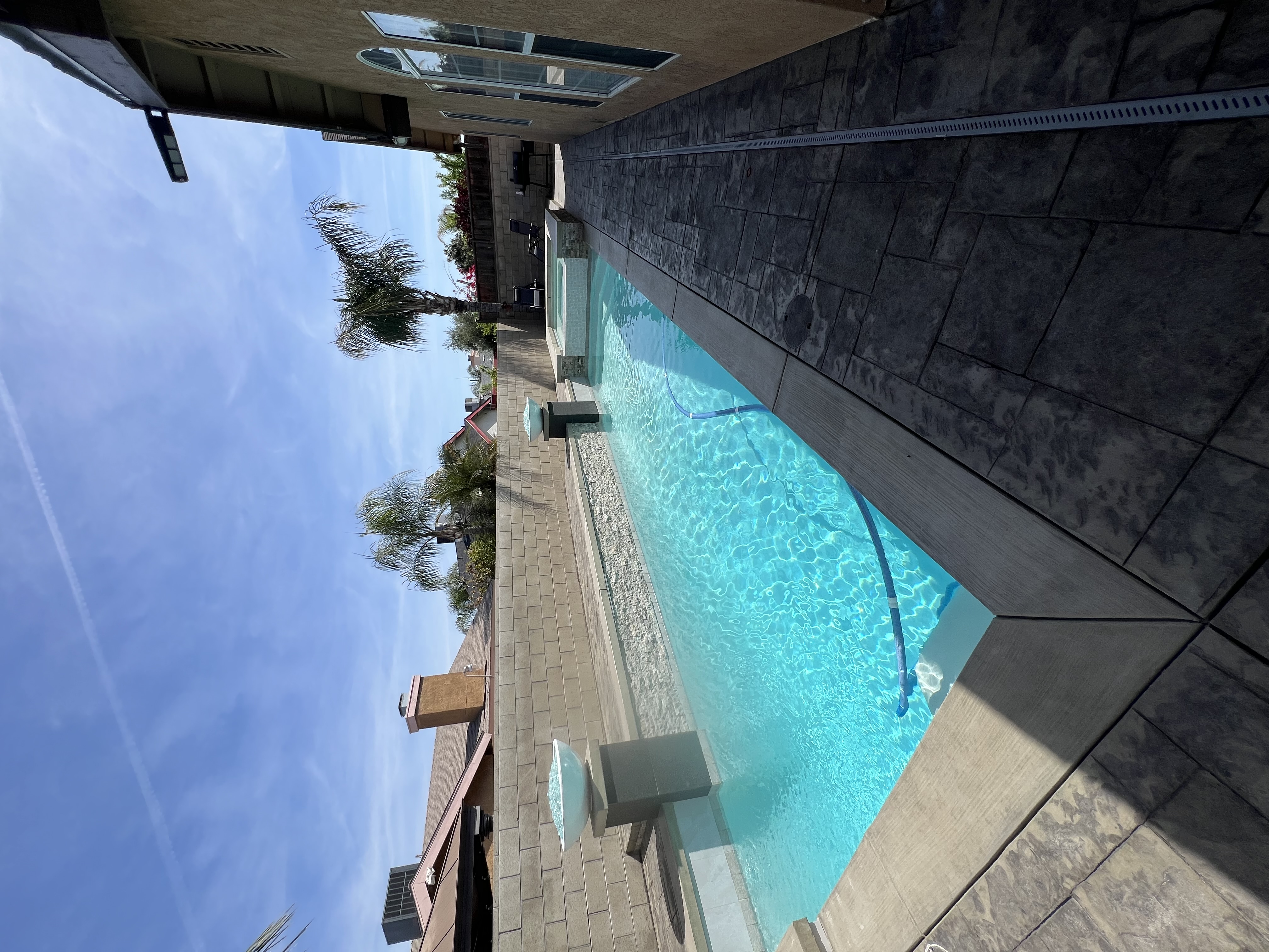 Narrow lot pool with fire bowls and stacked stone