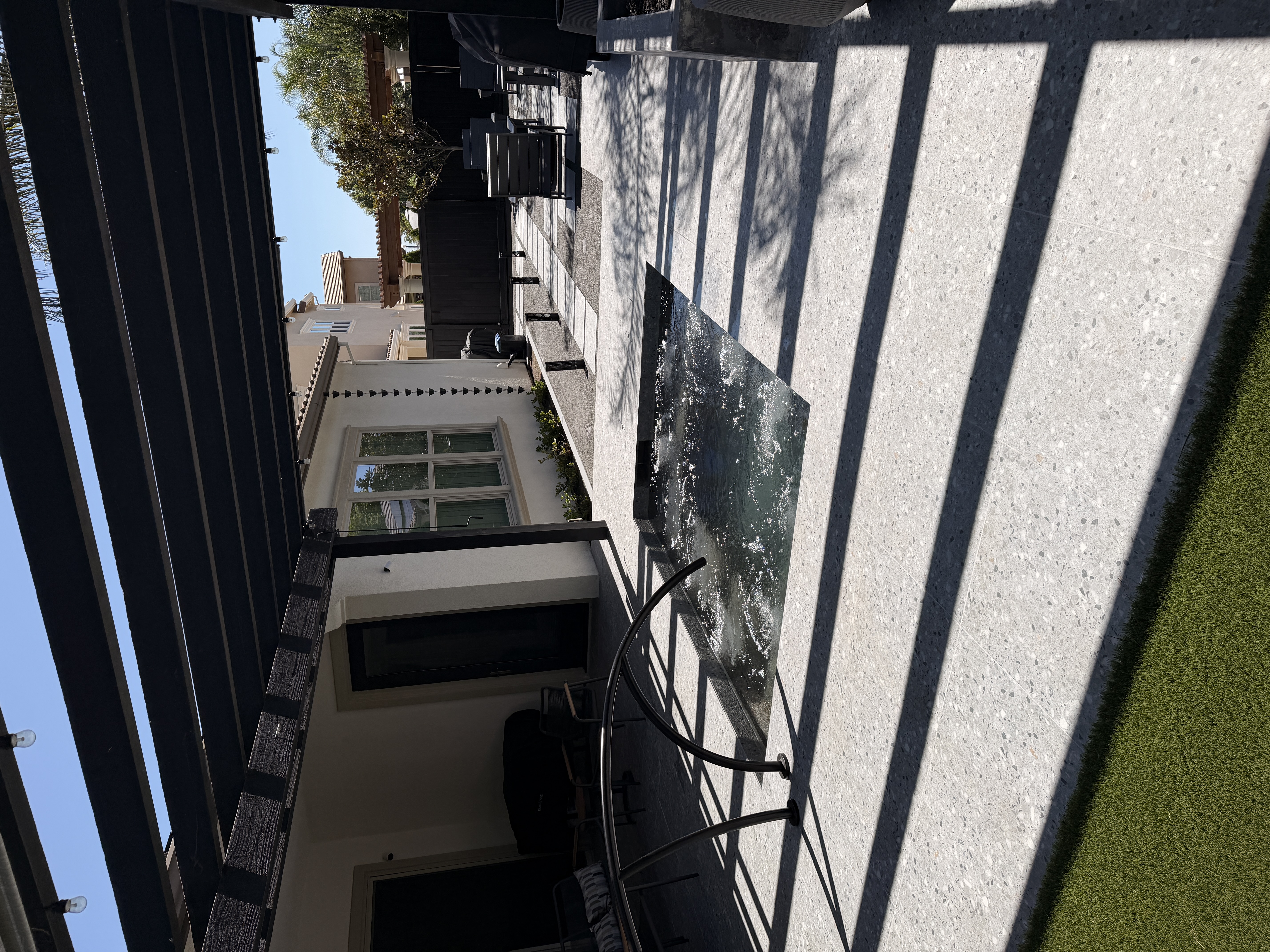 Sunken modern spa under black pergola