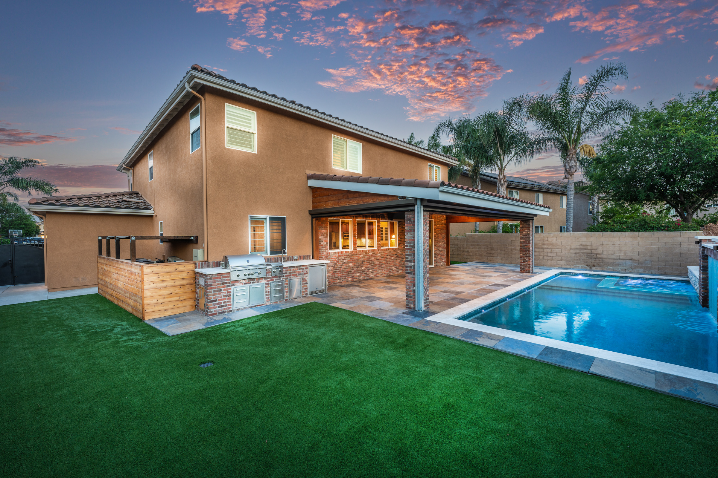 Pool and spa with outdoor kitchen at dusk